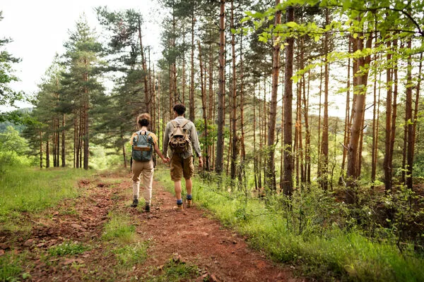 Unrecognizable Caucasian couple holding hands and hiking in the woods